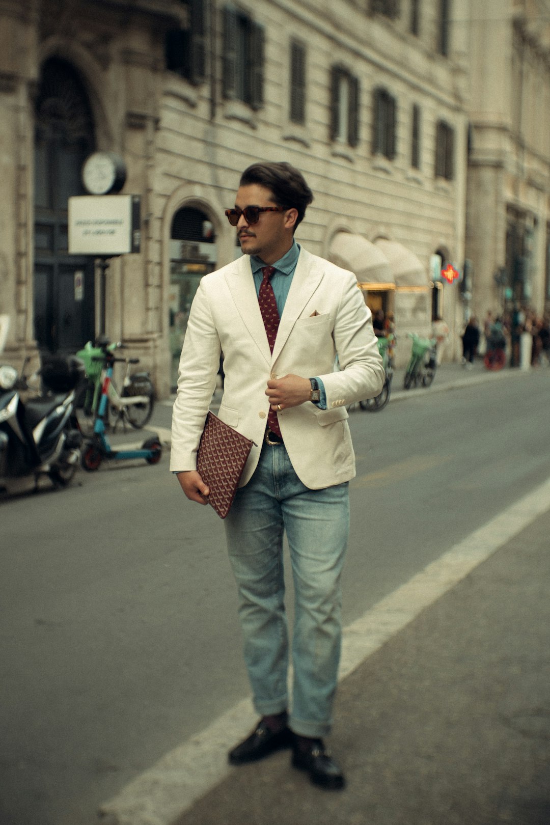 Uomo elegante in blazer di lino in una piazza italiana soleggiata